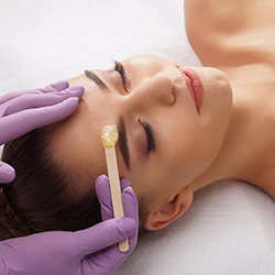 Eyebrow waxing with honey-colored wax